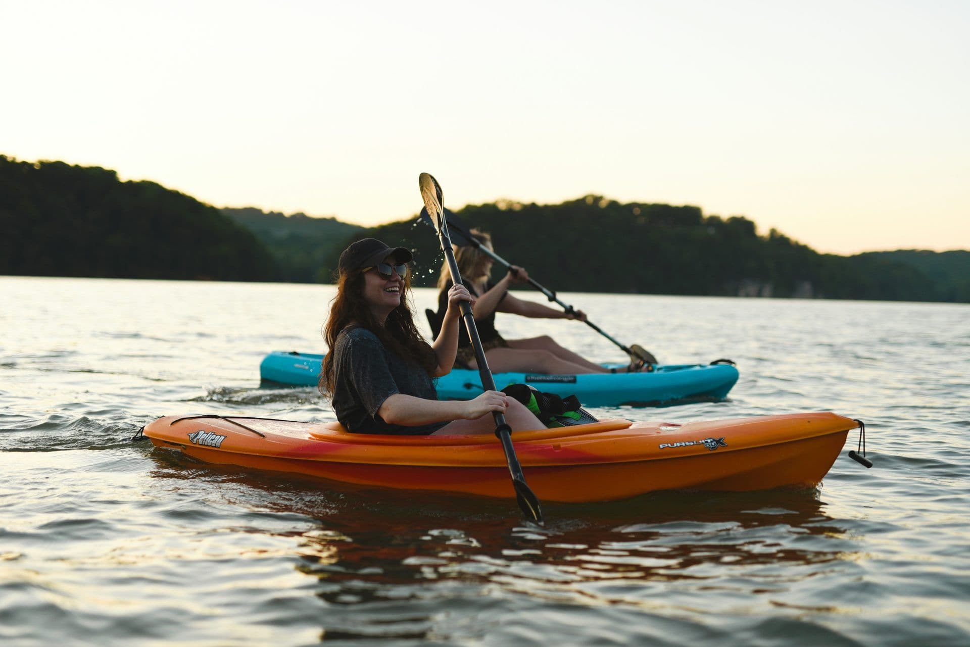 Two people kayaking on a lake at sunset, ideal for a corporate team building or outdoor team activity.