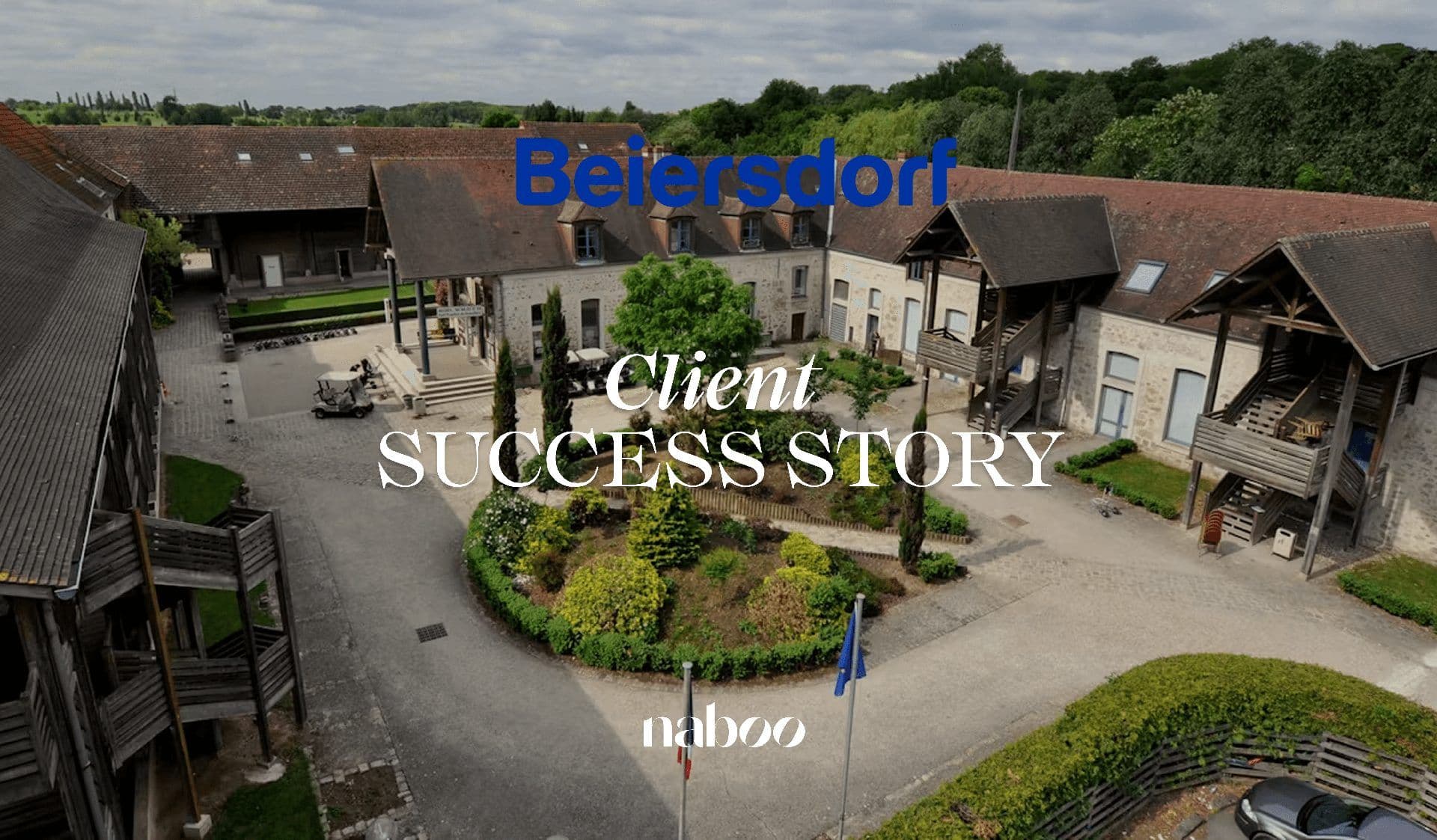 Aerial view of a historic stone corporate event venue with red tile roofs and a landscaped courtyard.