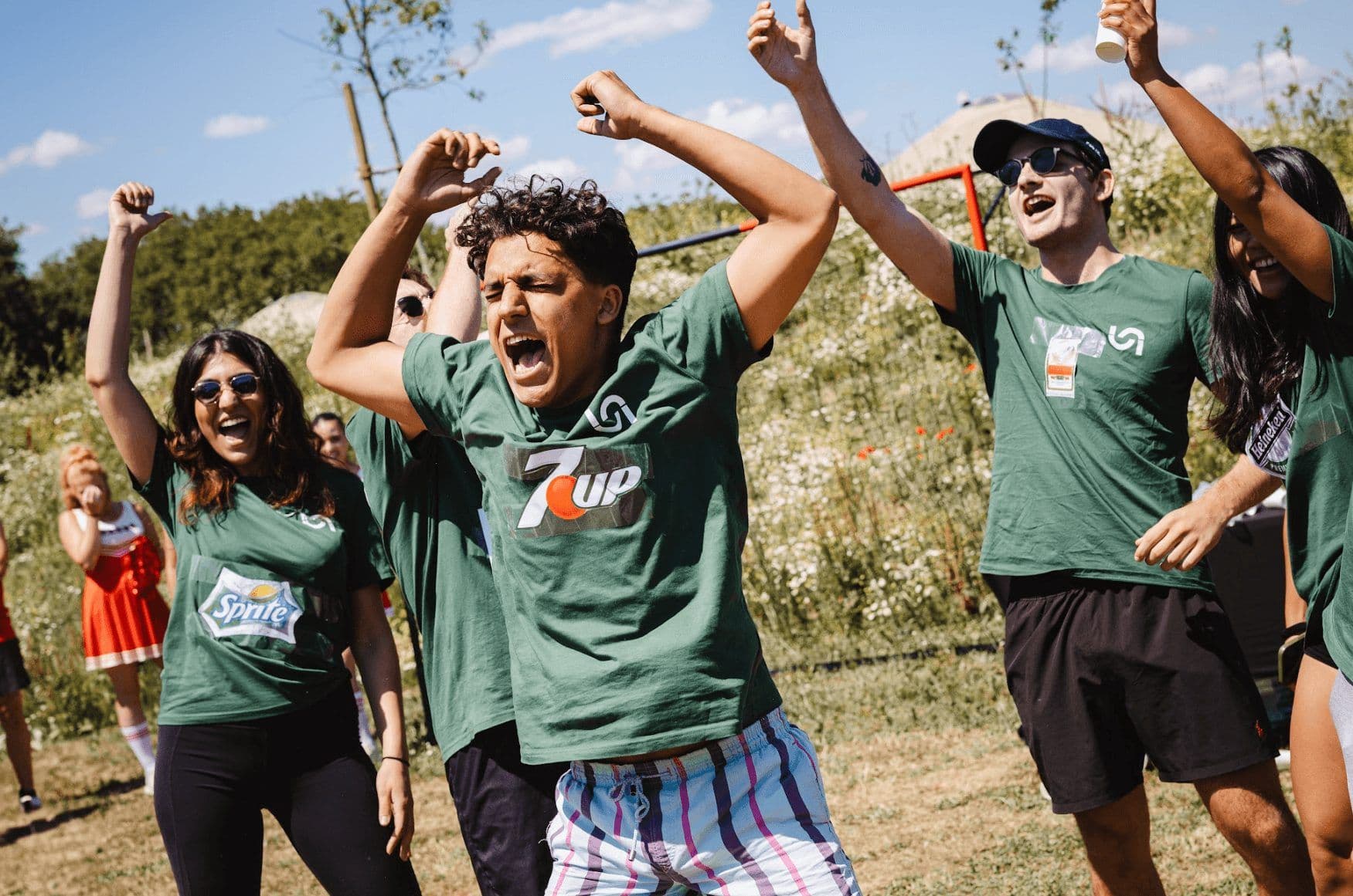 Excited employees cheer during an outdoor team building activity or company away day.
