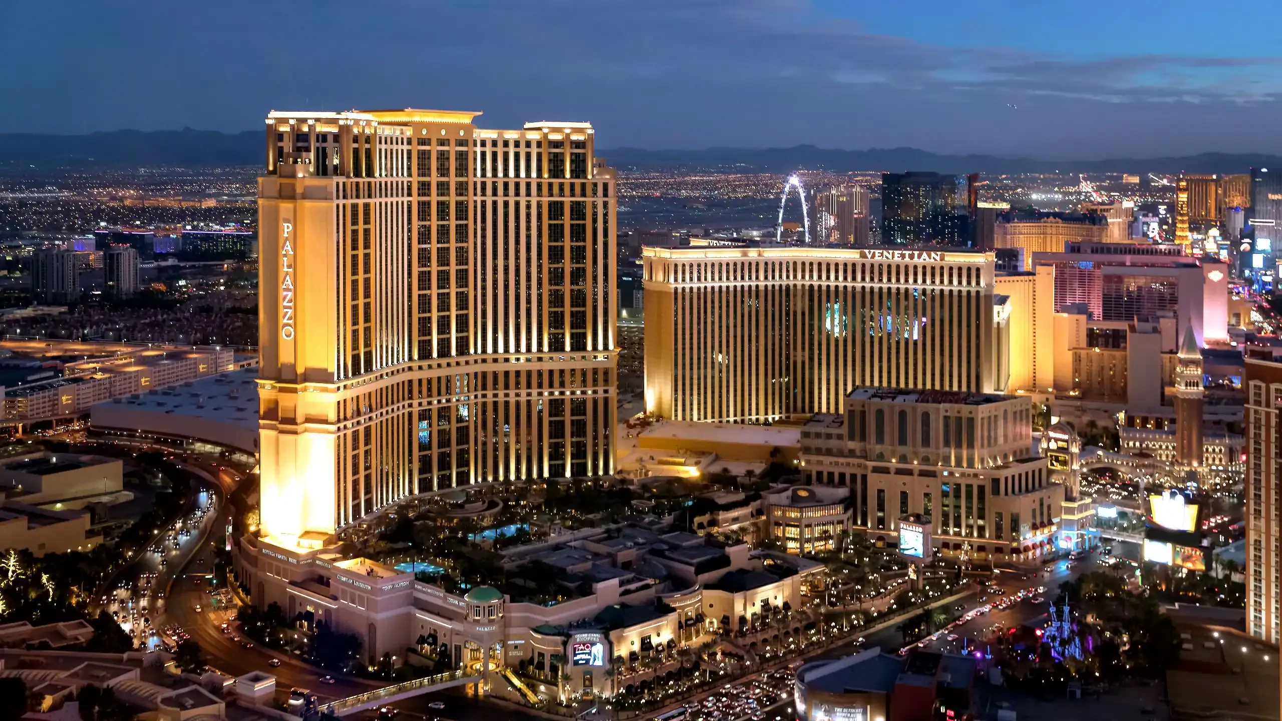 Aerial view of the illuminated Palazzo and Venetian luxury corporate event venues in Las Vegas at dusk.