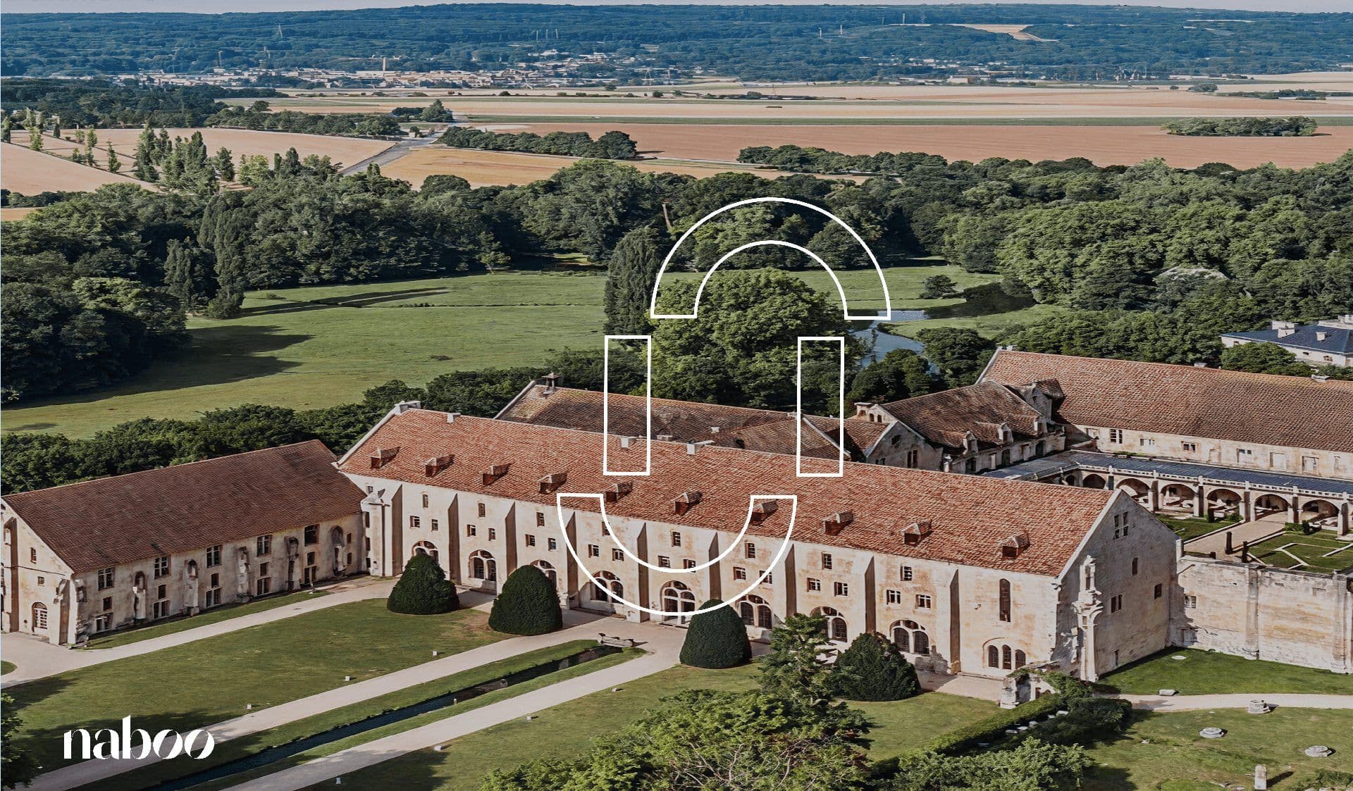 Aerial view of Royaumont Abbey, a historic corporate event venue in France, surrounded by green landscapes.