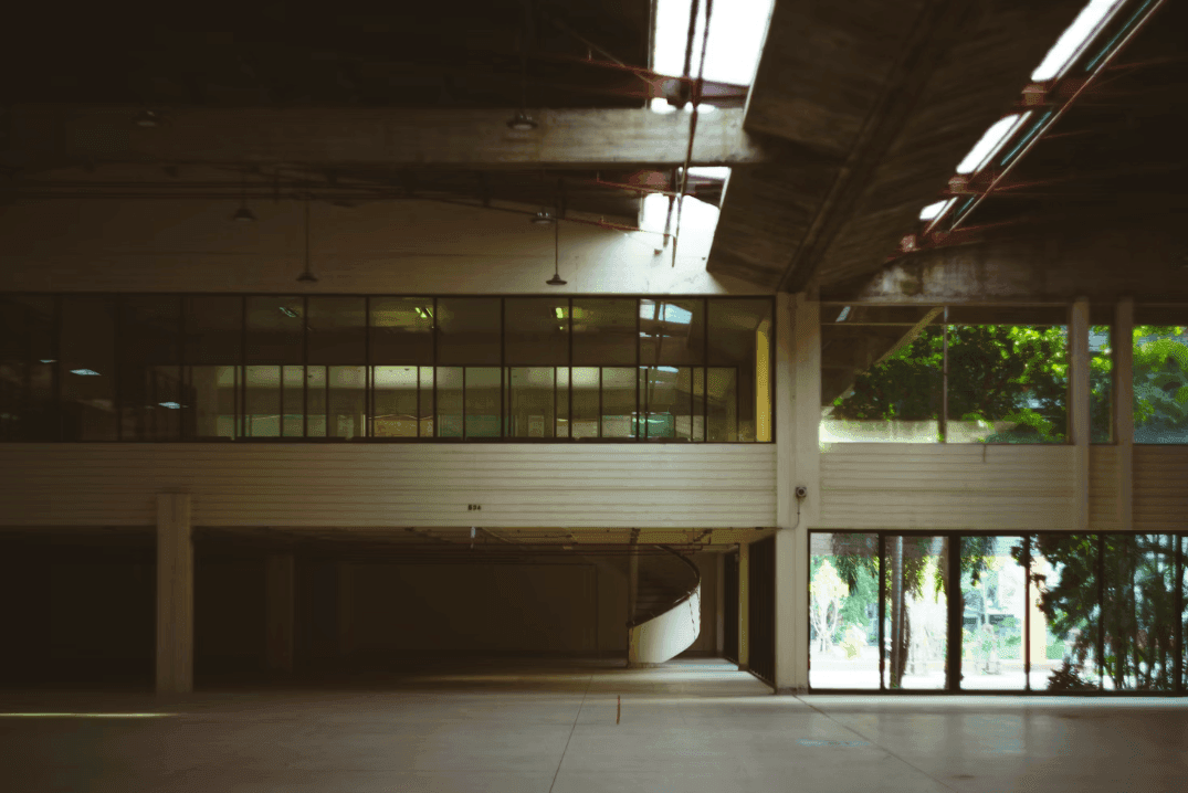 Spacious industrial-style corporate event venue with high ceilings, a mezzanine, and natural light.