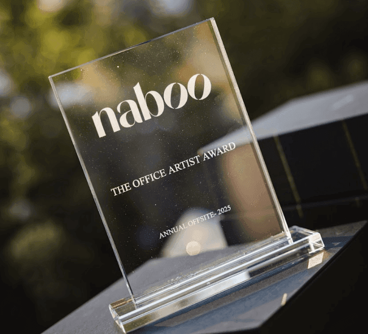 A clear acrylic corporate award engraved with 'naboo THE OFFICE ARTIST AWARD ANNUAL OFFSITE - 2025'.