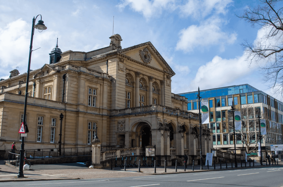 Historic Cheltenham Town Hall, a grand corporate event venue, stands beside a modern office building.