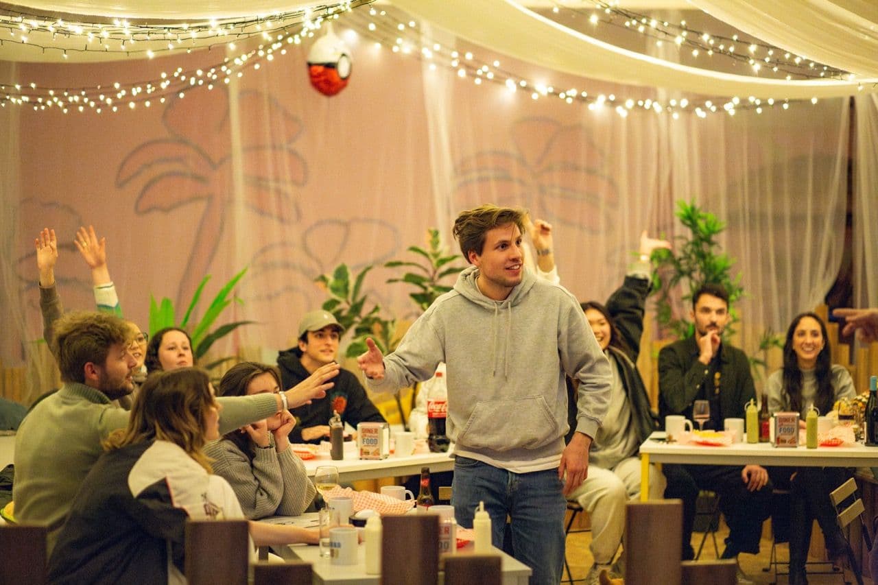 Attendees raise hands during an interactive team building workshop in a unique