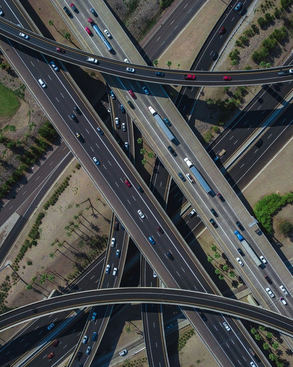 Aerial view of a complex highway interchange with cars and trucks, representing event logistics.