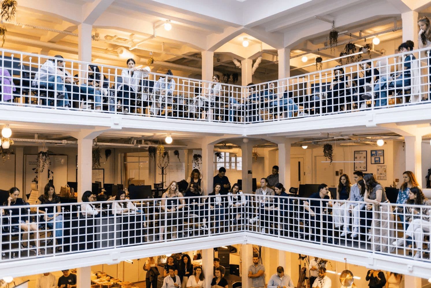 Professionals gather in a vibrant, multi-level corporate event venue, suitable for large group workshops.