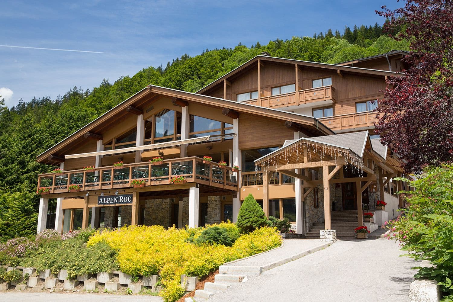 Alpen Roc, a multi-story wooden alpine hotel and corporate event venue with outdoor terraces