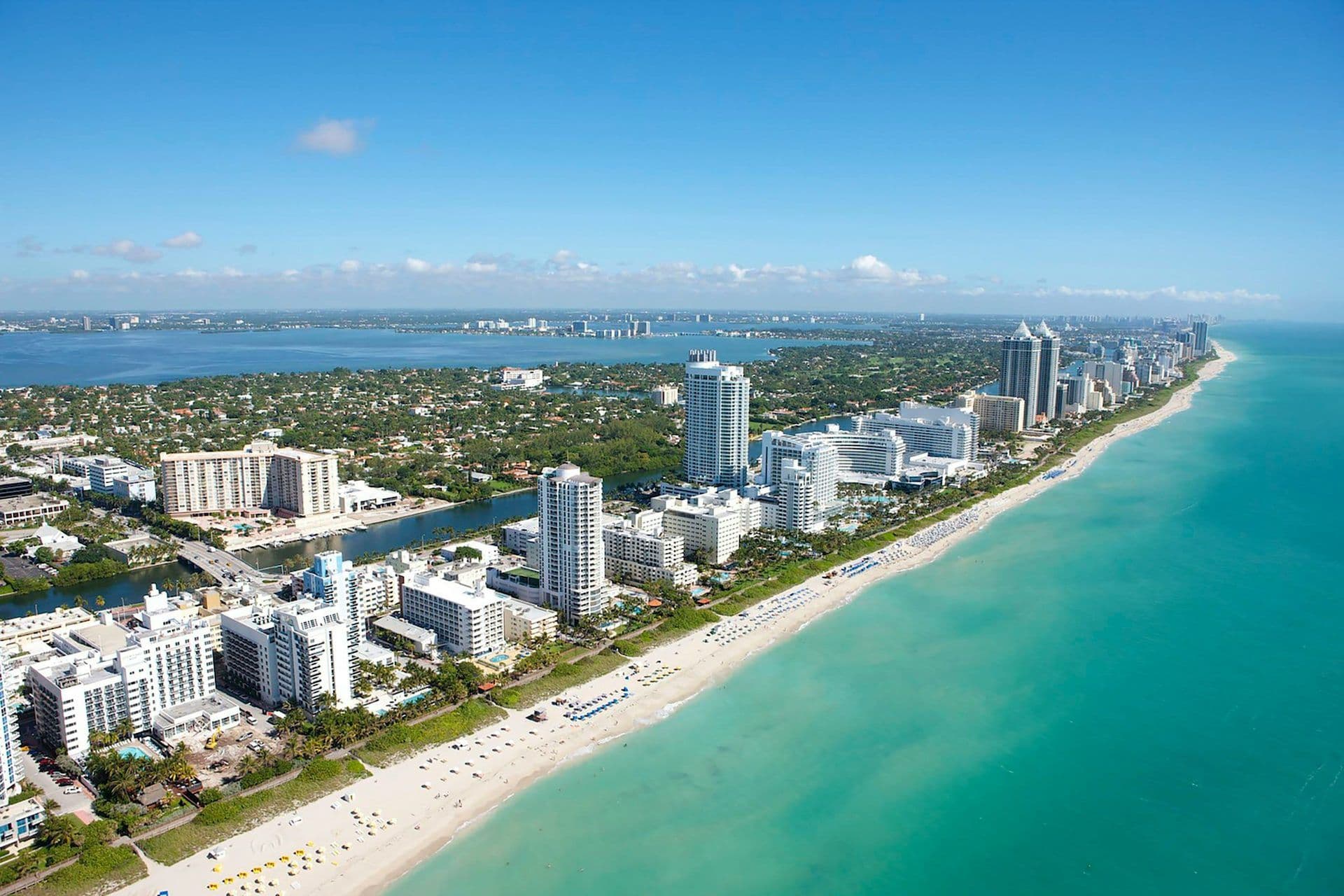 Aerial view of Miami Beach, Florida, with a sandy beach, turquoise ocean, and corporate event venues.