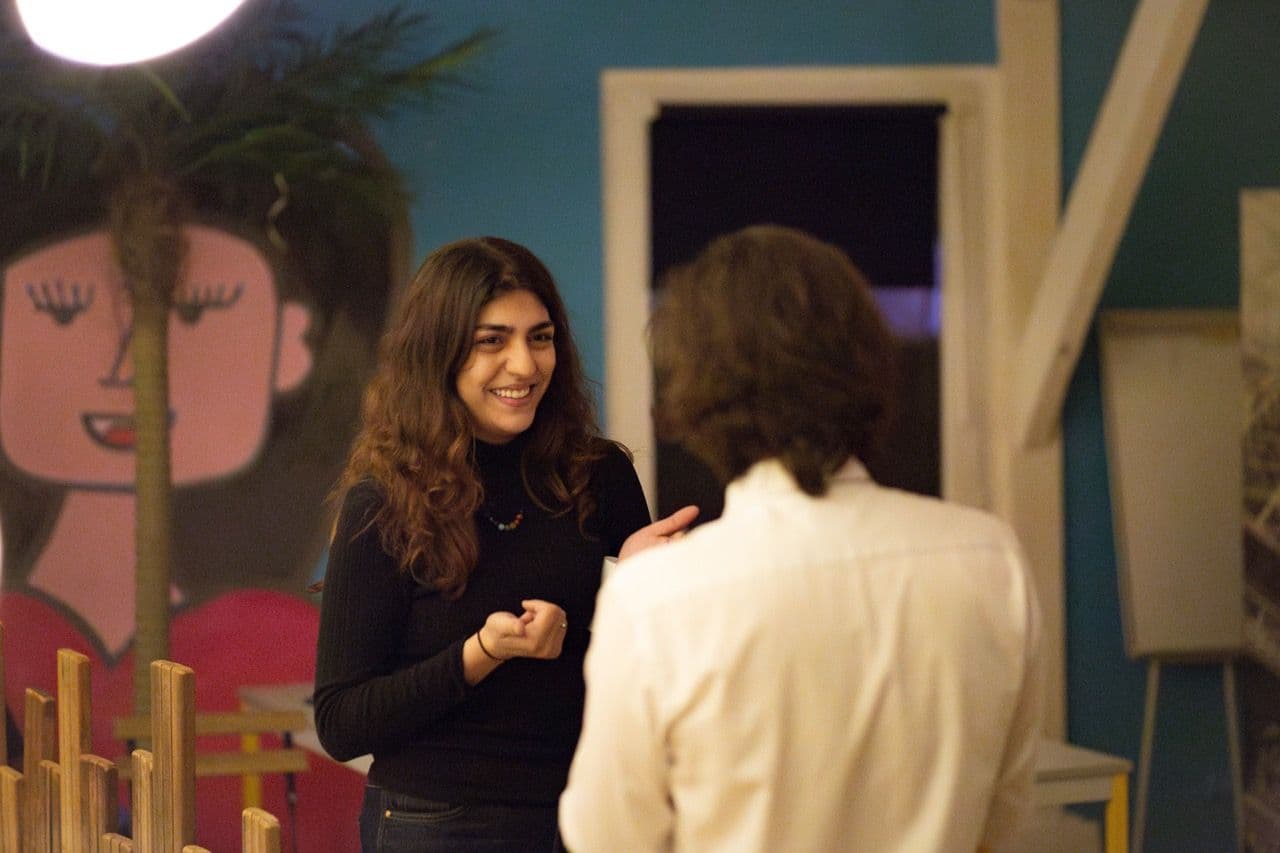 Smiling woman talking to another person in a vibrant, unique corporate event venue.