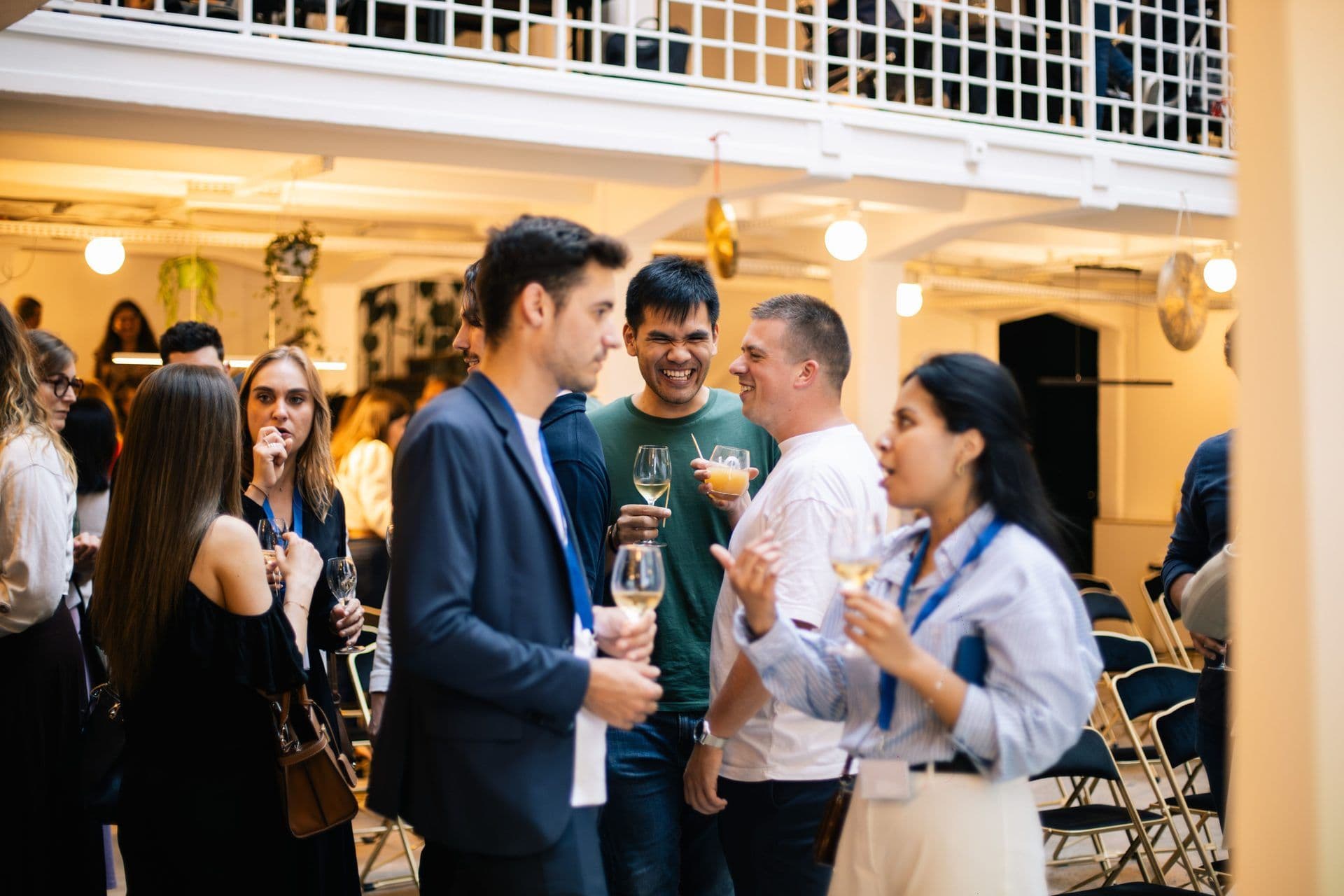 Diverse professionals enjoy a networking cocktail reception at a lively corporate event venue.