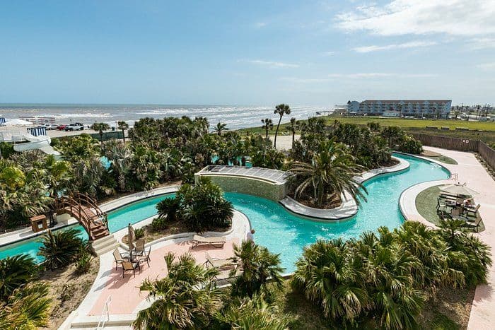 Coastal resort with a winding lazy river, palm trees, and ocean views, ideal for corporate retreats.