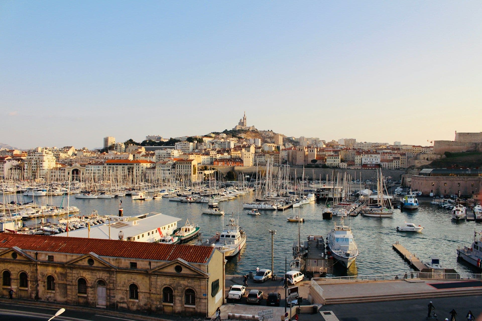 Marseille's Old Port, a vibrant waterfront venue with boats, historic buildings, and Notre-Dame de la Garde.
