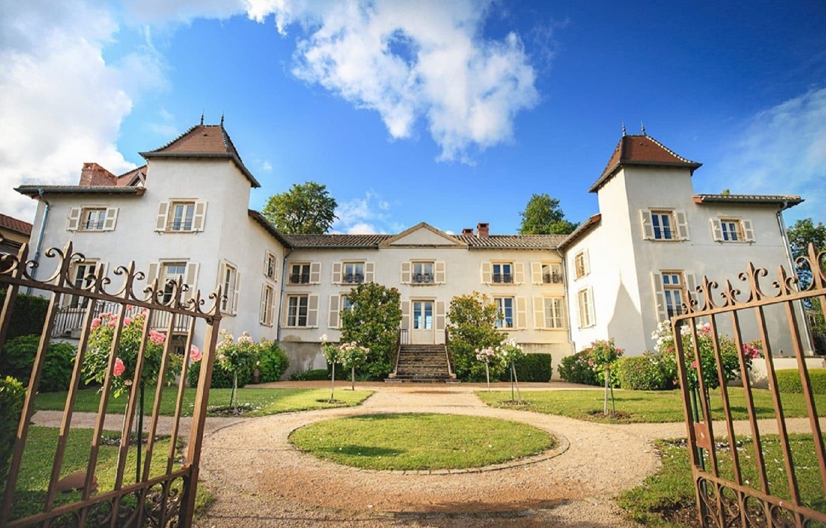 Historic white château with a grand facade and landscaped garden, ideal for corporate events.