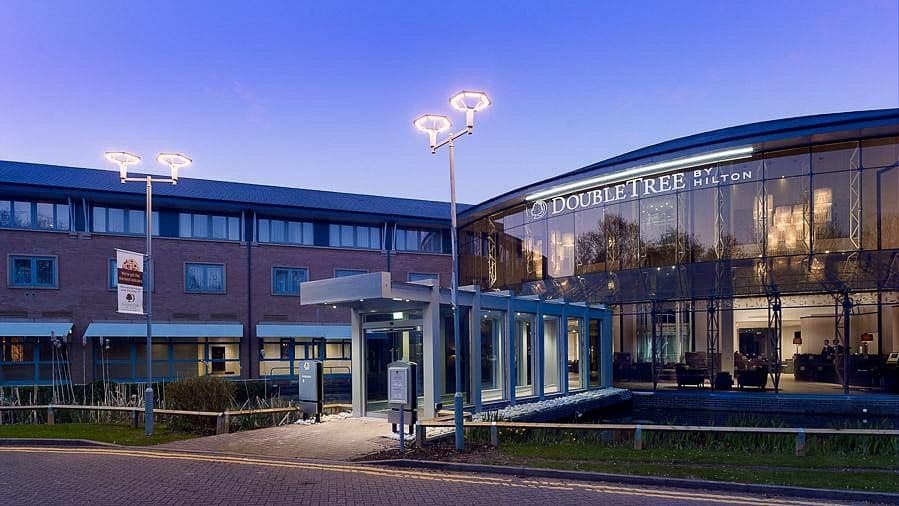 Exterior view of the DoubleTree by Hilton hotel, a modern corporate event venue with a striking glass facade.