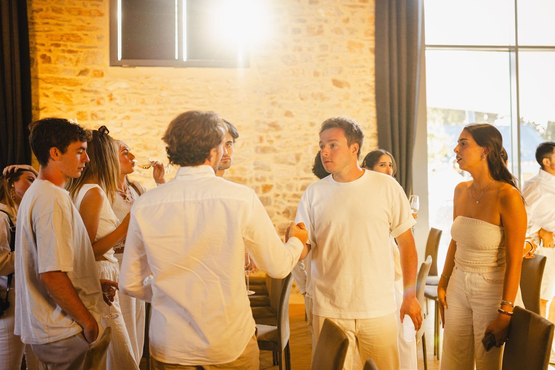 Attendees networking and shaking hands at a corporate team building event in a unique venue.