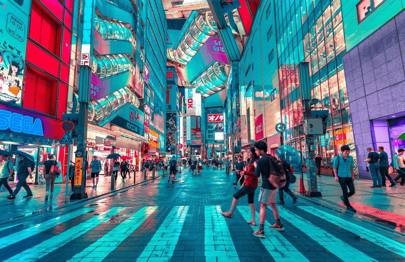 Vibrant, neon-lit street in Tokyo with tall buildings, numerous pedestrians, and colorful signs.