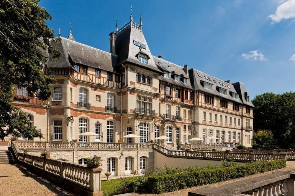Elegant historic chateau with a grand facade and a spacious outdoor terrace, perfect for corporate events.