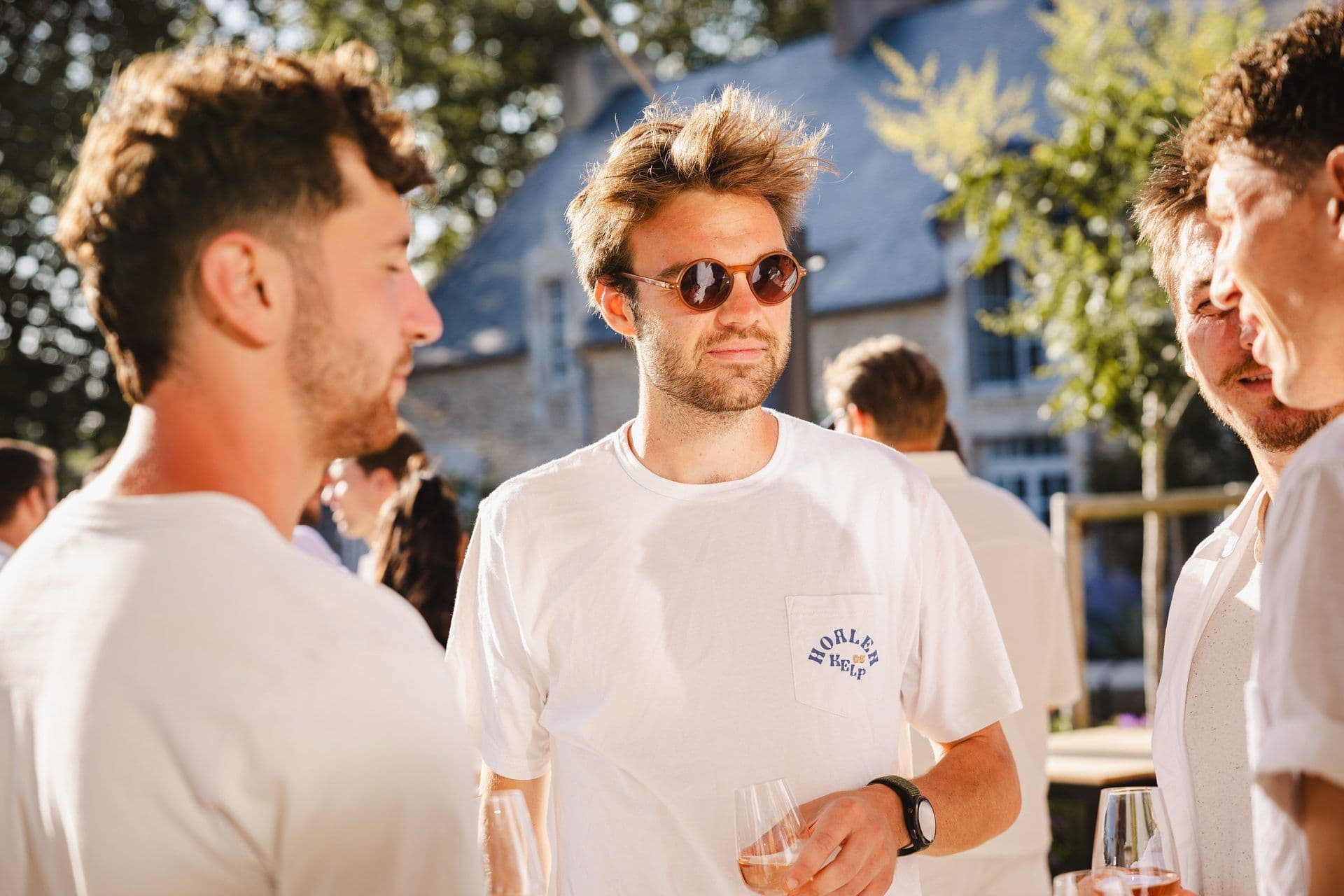 Men enjoy a sunny outdoor cocktail reception at a historic corporate event venue.