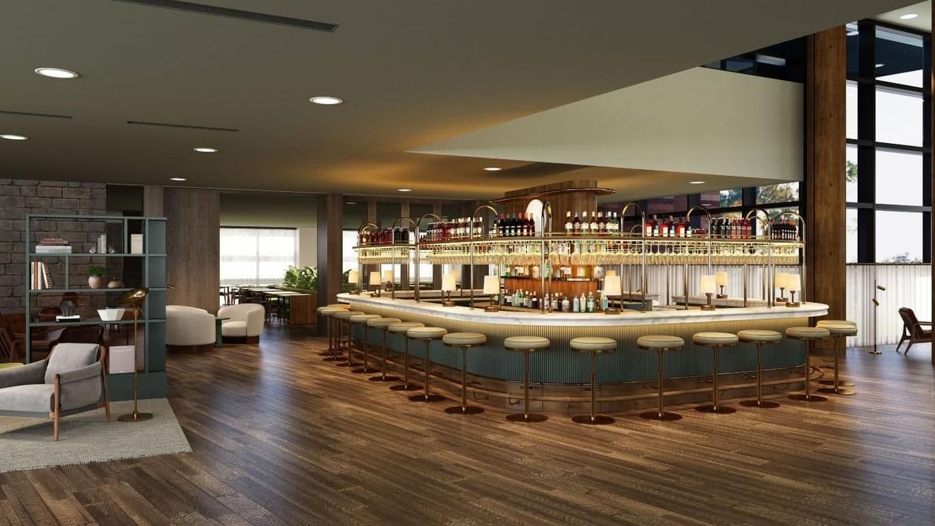 A modern, well-stocked bar with numerous stools in a sophisticated corporate event venue.
