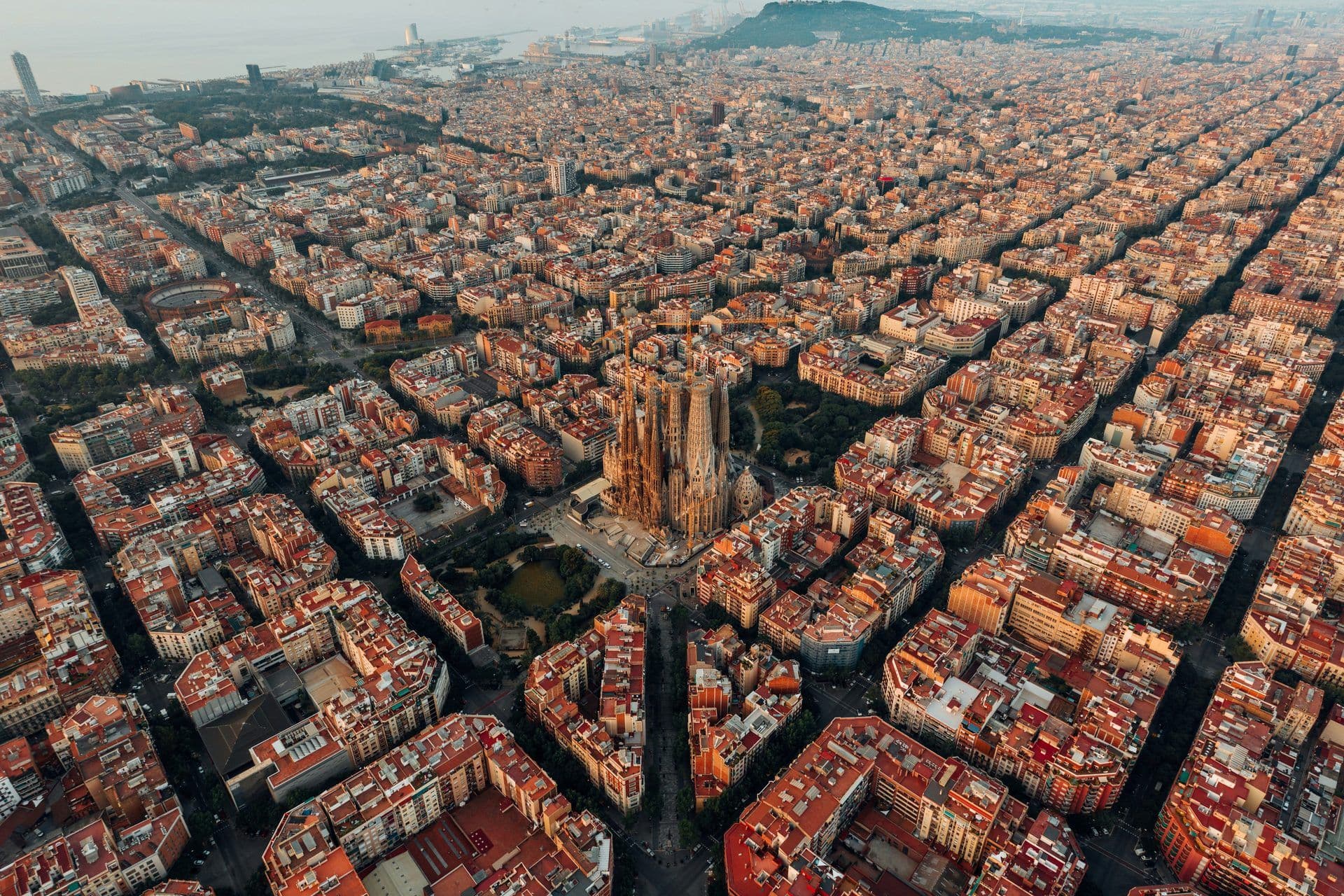 Aerial view of Barcelona, Spain, featuring the iconic Sagrada Familia amidst the city's grid.