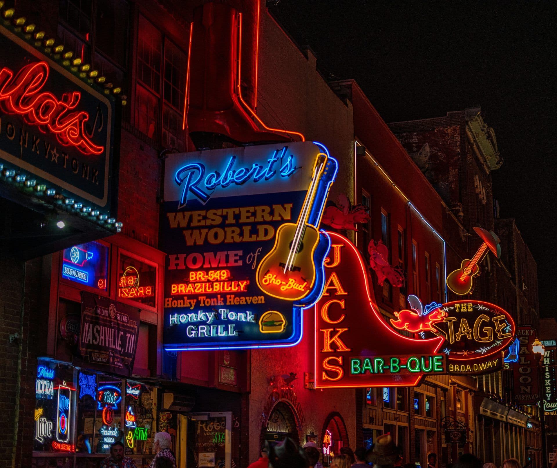 Vibrant neon signs illuminate unique corporate event venues and honky-tonk bars in Nashville, Tennessee.
