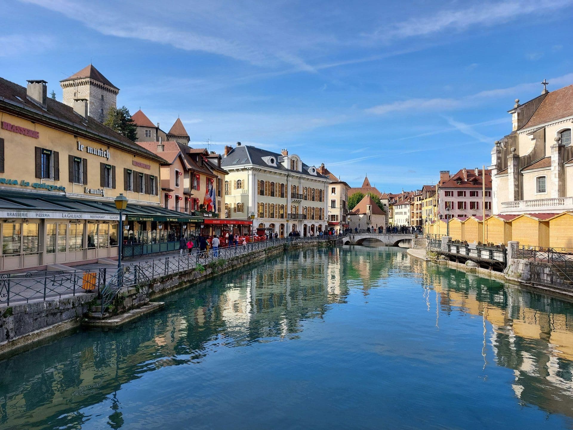 Historic waterfront in Annecy, France, featuring charming buildings, canal-side restaurants, and bridges.