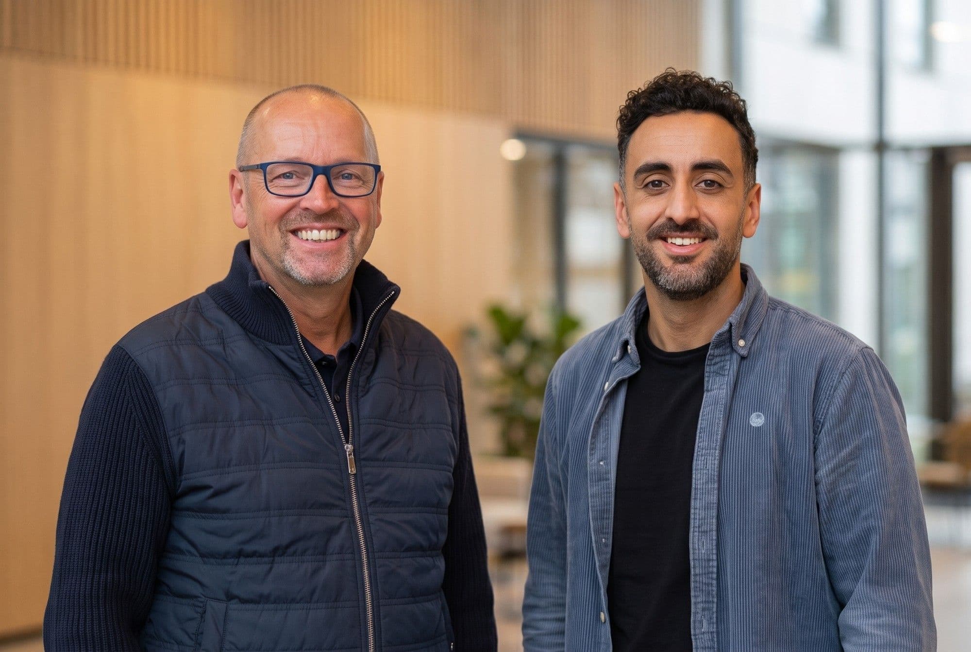 Two company leaders standing together in a modern office, marking the Naboo and pro-ven acquisition