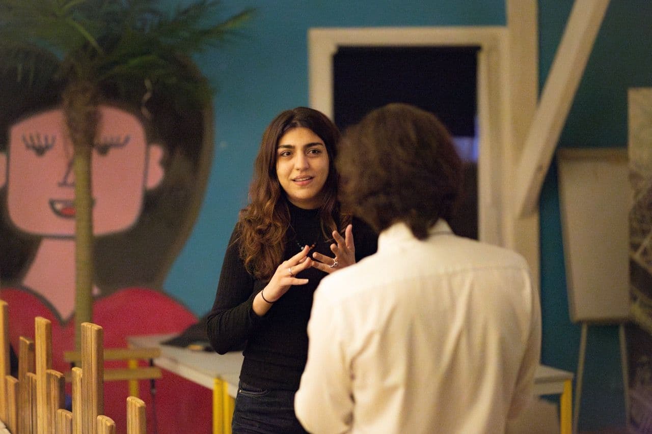 Two professionals engage in a discussion within a vibrant meeting room, ideal for a corporate seminar.