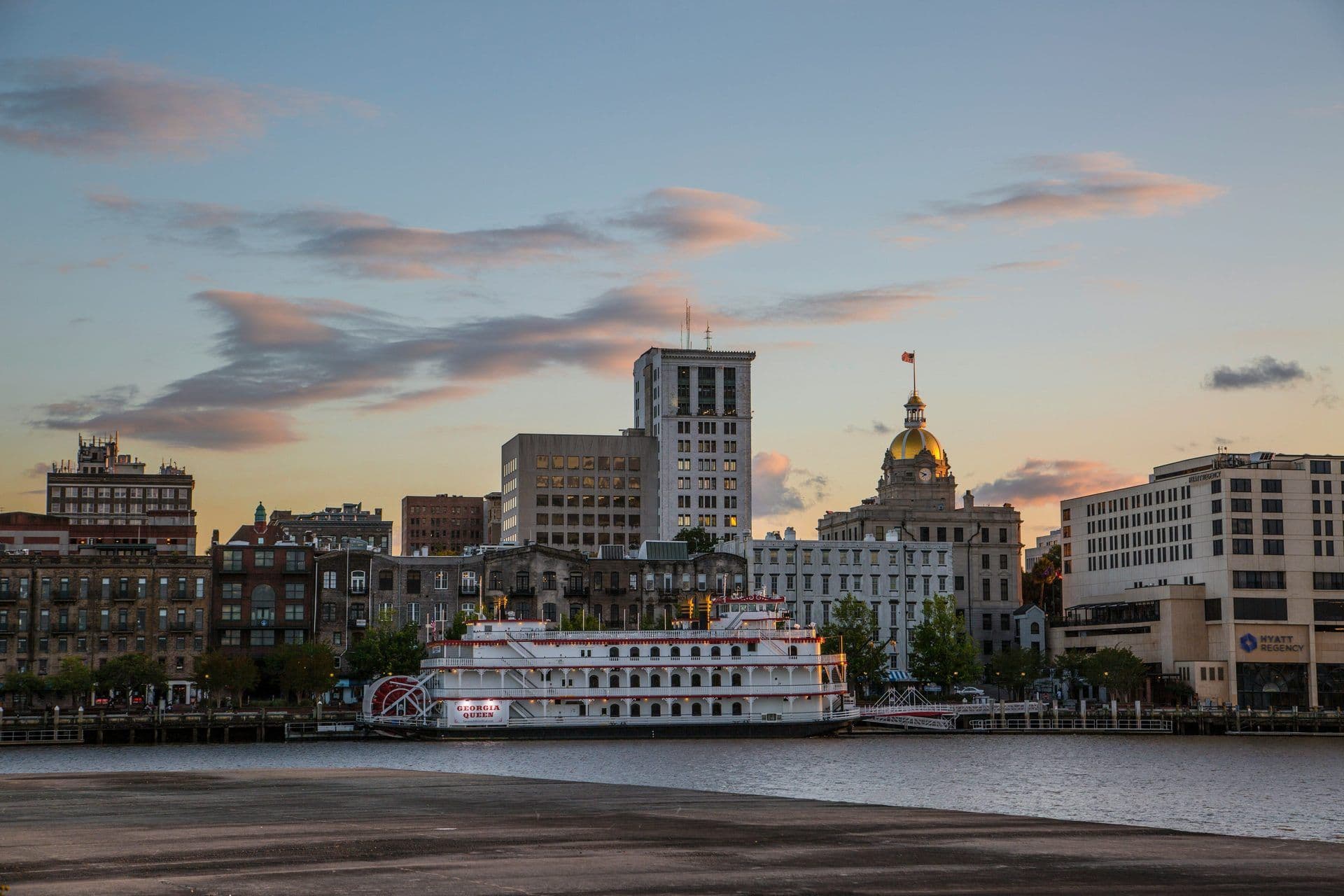 Savannah, Georgia cityscape at sunset with a paddlewheel riverboat, a unique waterfront venue.