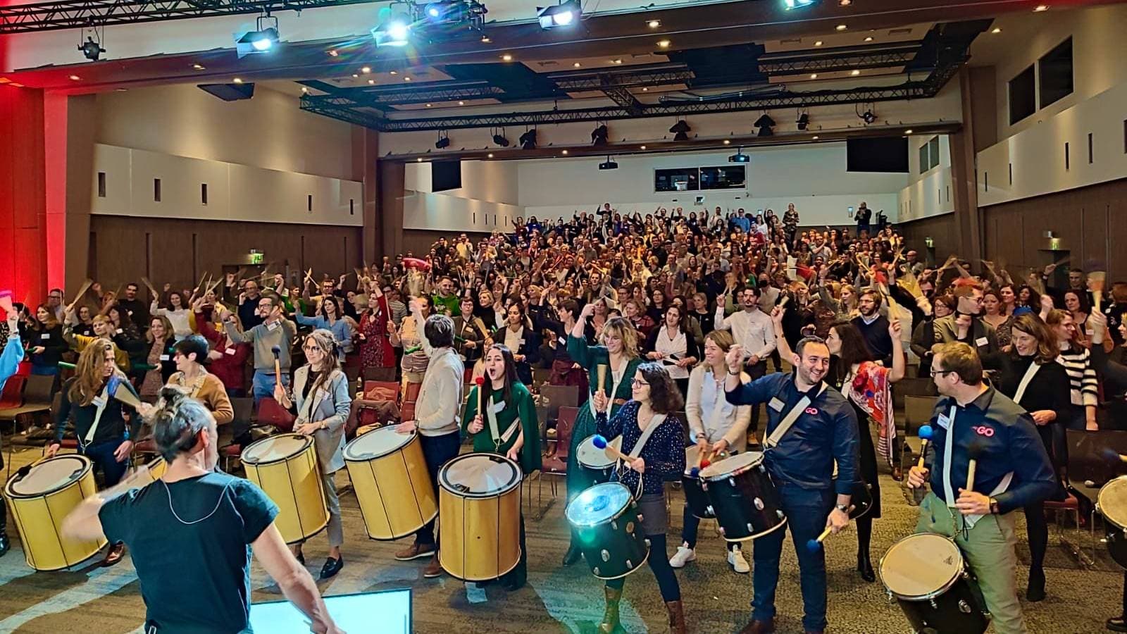 Team building percussions brésiliennes en salle – 350 participants créent ensemble un orchestre rythmique dans un contexte de séminaire d’entreprise.
