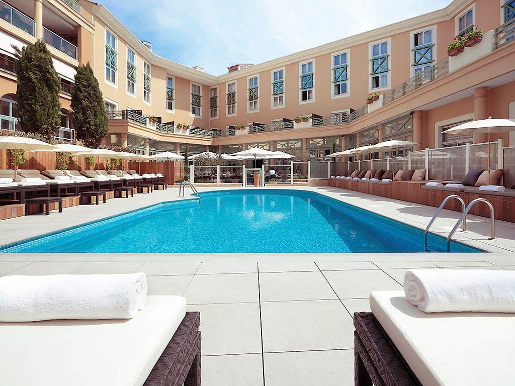 Sunny outdoor swimming pool and lounge area at a resort, ideal for a corporate retreat or team offsite.