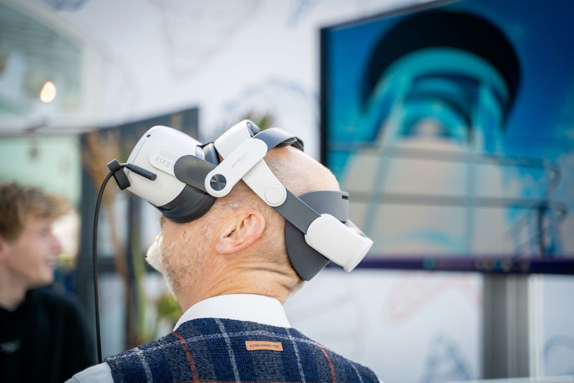 An attendee at a corporate event wears a VR headset, participating in an interactive virtual activity.