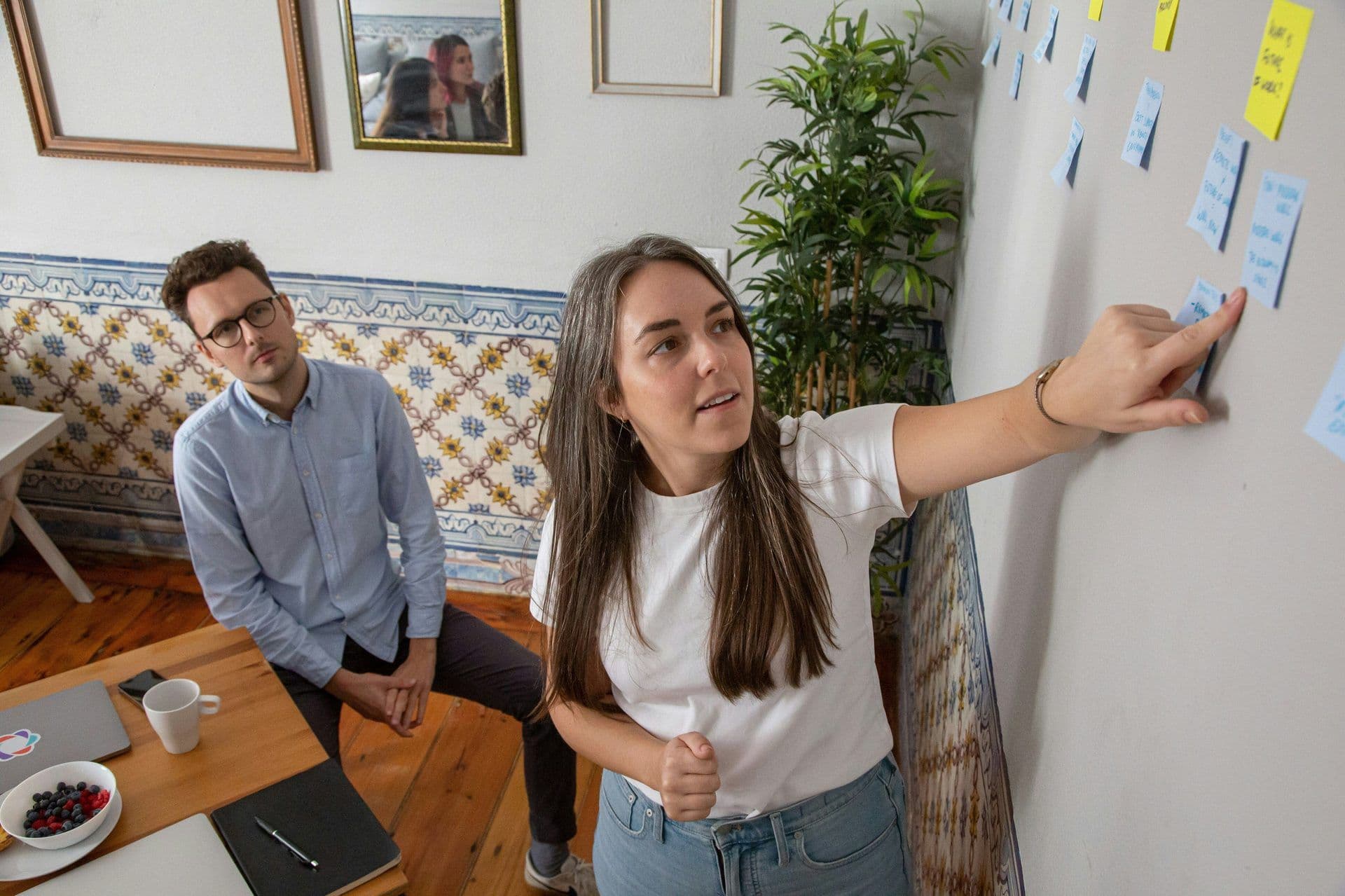 Woman points at sticky notes during a team workshop in a unique corporate meeting room.