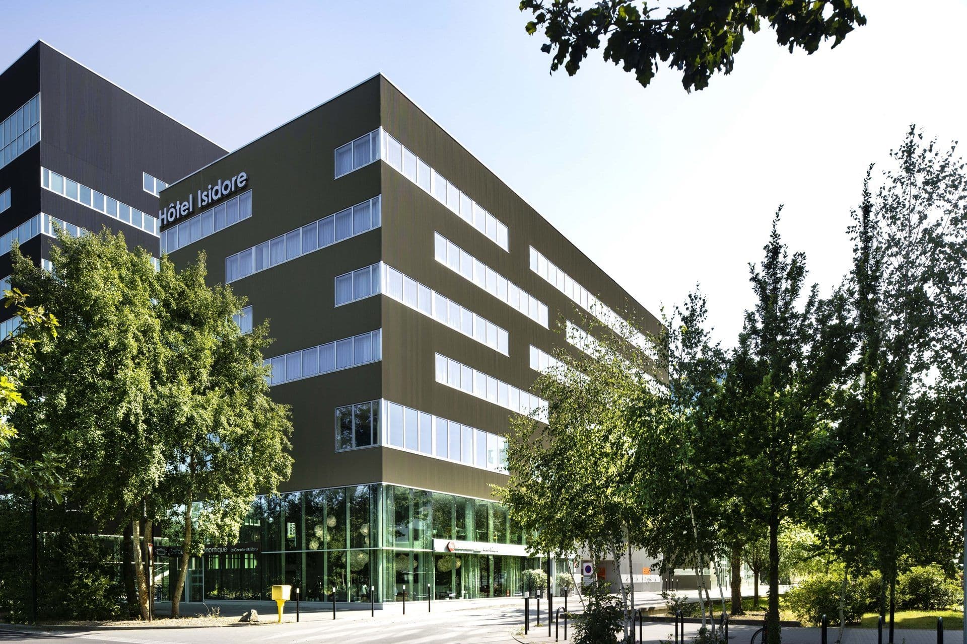 Exterior view of Hôtel Isidore, a modern corporate event venue in Rennes, France, with trees.