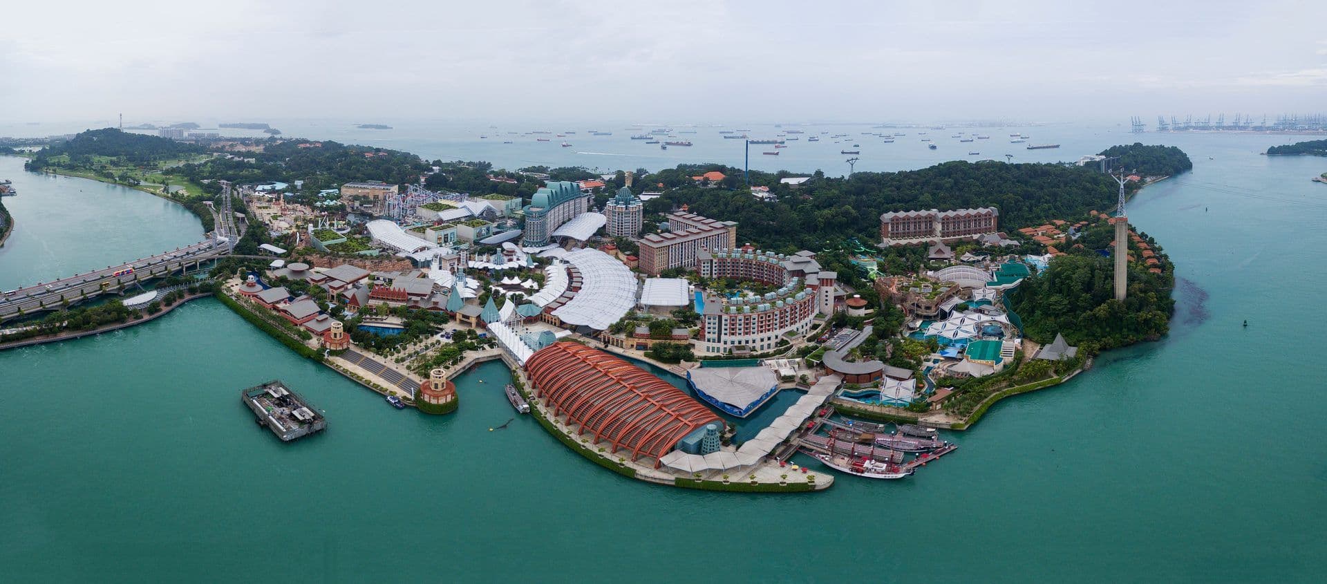 Aerial view of Sentosa Island, Singapore, showcasing integrated resorts, theme parks, and waterfront venues.