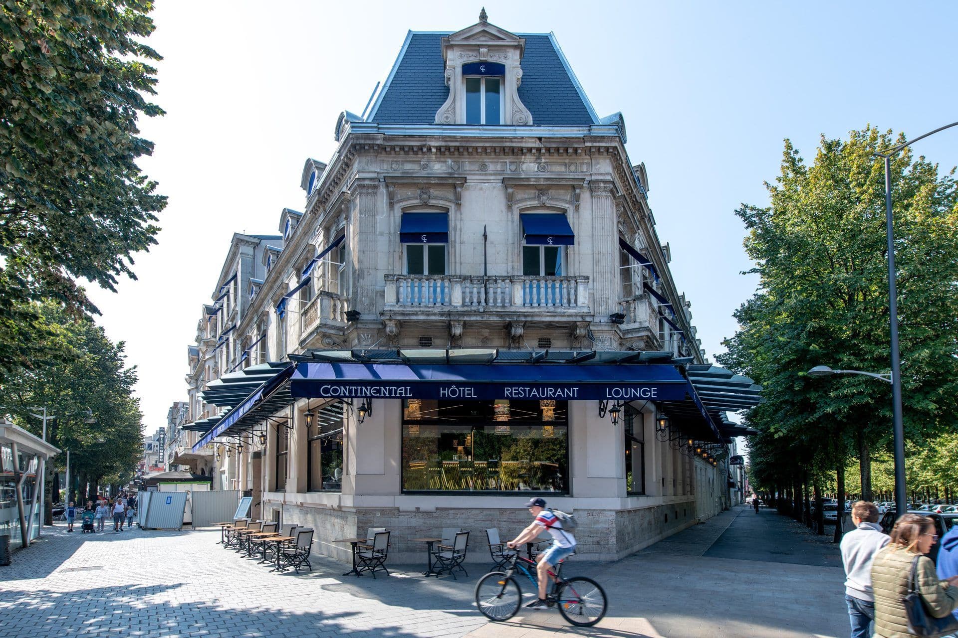 Historic hotel and restaurant with outdoor terrace seating, ideal for corporate events in a European city.