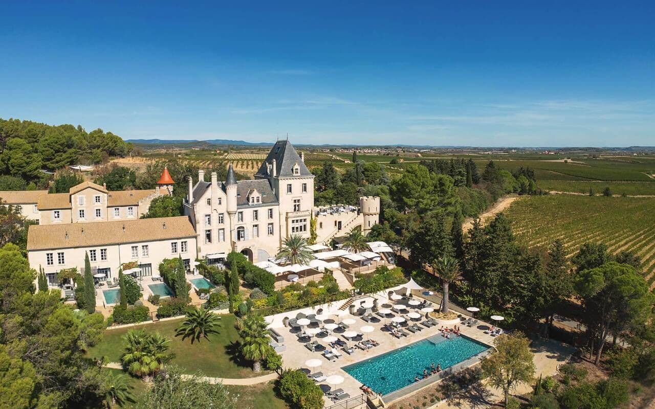 Luxury chateau estate with a swimming pool, lush gardens, and vineyards, ideal for corporate retreats.