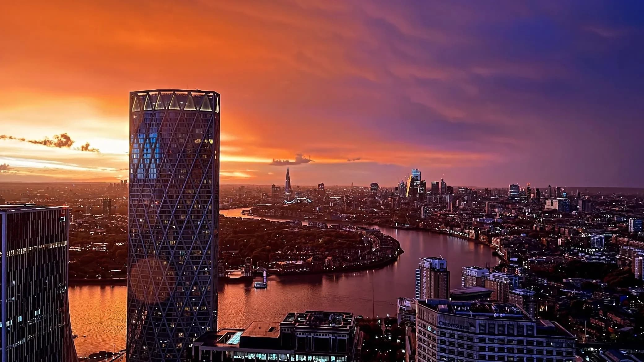 Stunning London skyline at sunset, featuring a modern skyscraper, the River Thames, and city lights.