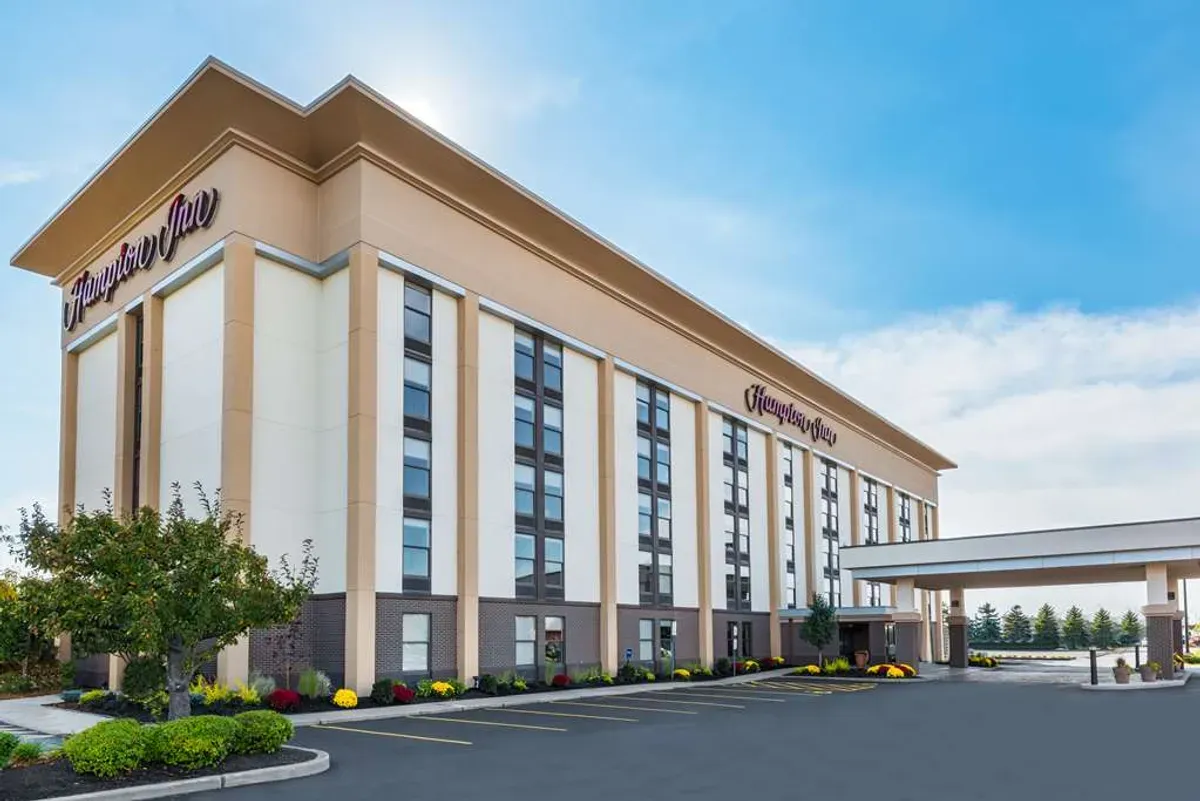 Exterior view of a modern Hampton Inn hotel, a suitable corporate event venue with parking.