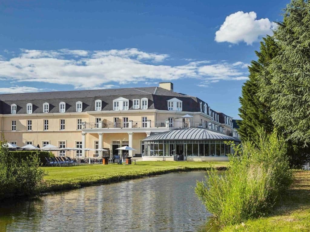 Elegant waterfront corporate event venue with a glass conservatory and outdoor terrace.