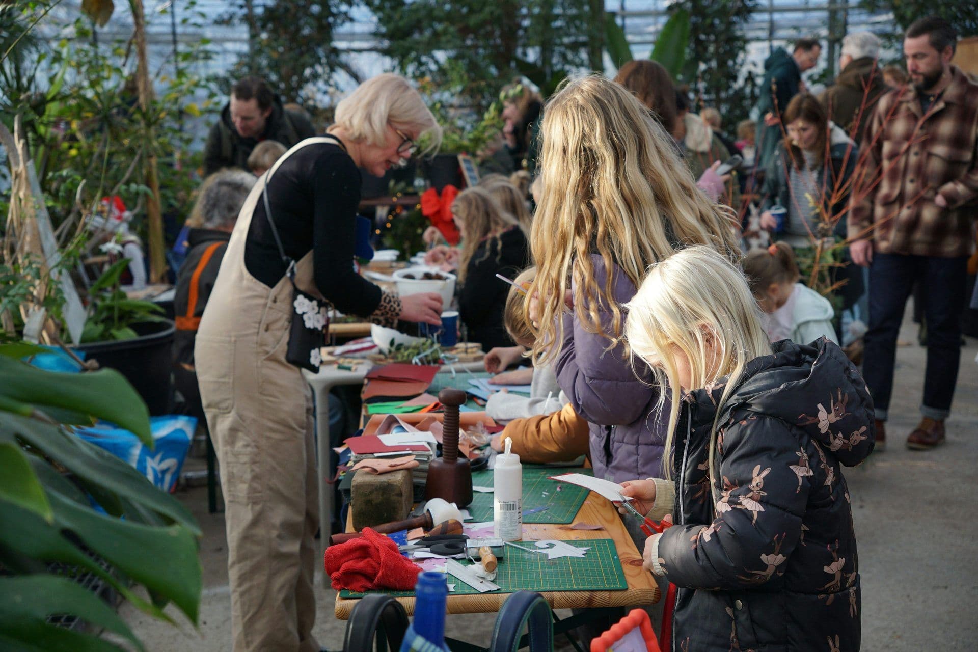 Attendees engage in a hands-on craft workshop within a unique, plant-filled corporate event venue.