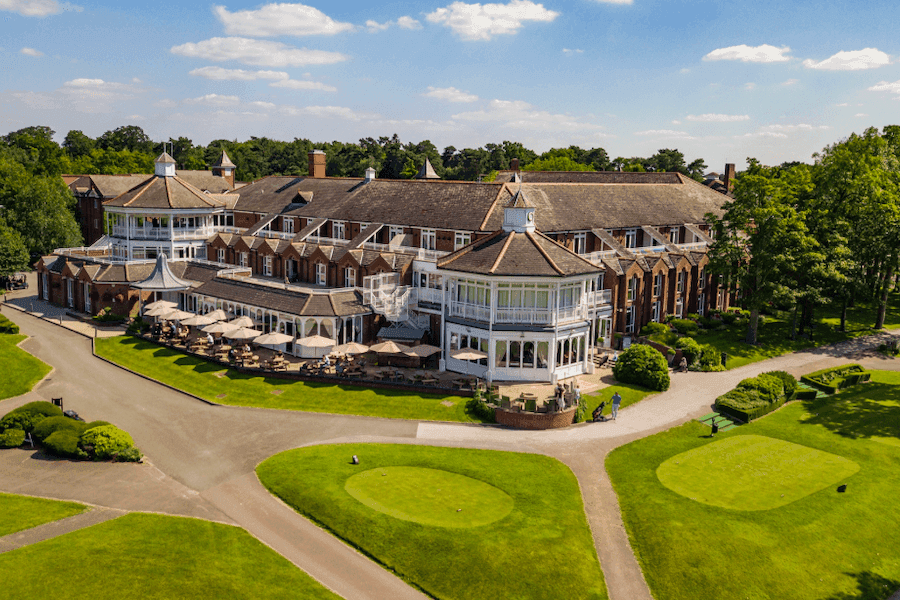 Aerial view of a sprawling corporate event venue with a golf course and outdoor terraces in the UK.