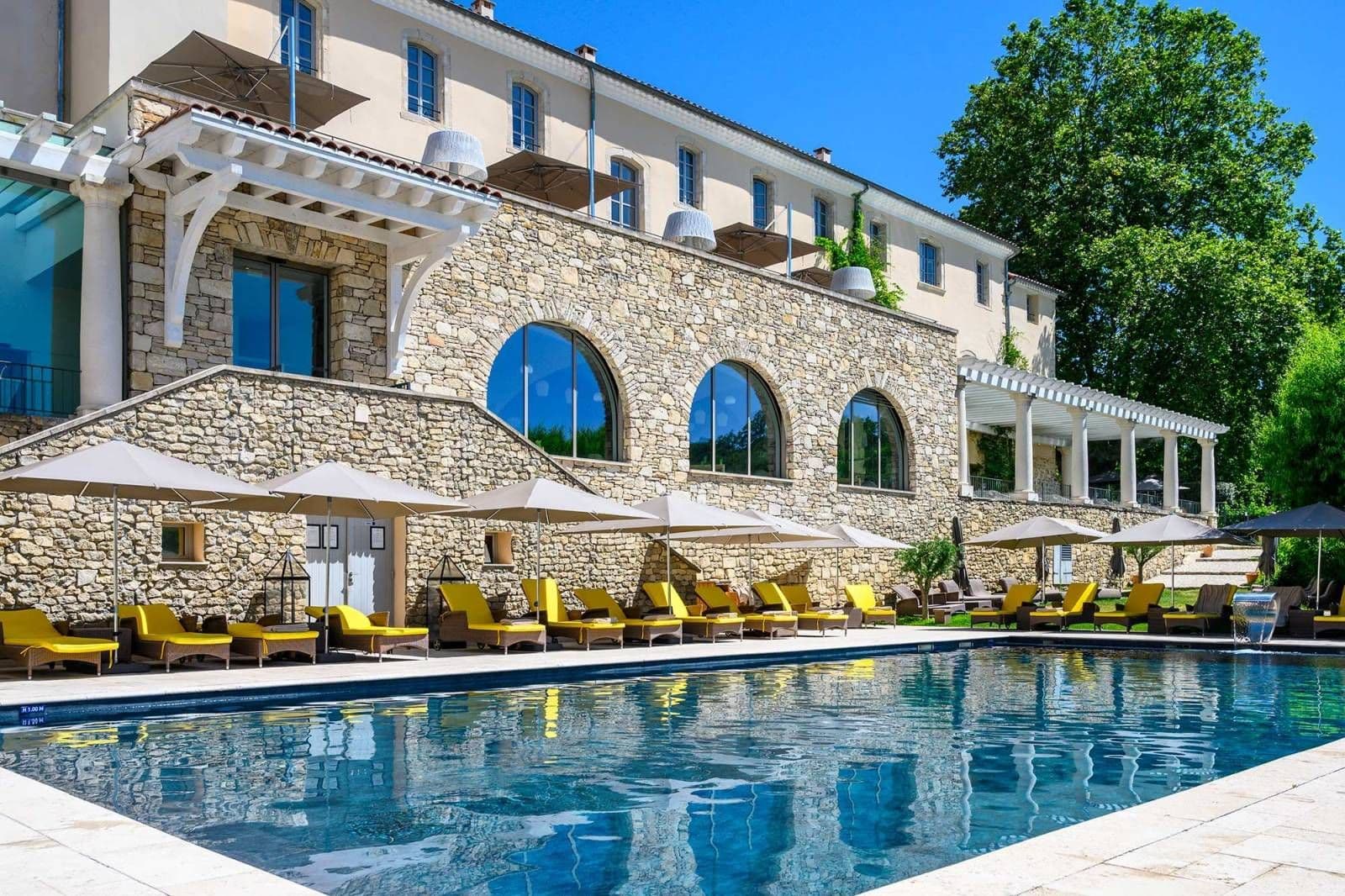 Historic corporate event venue featuring an outdoor swimming pool, sun loungers, and stone architecture.