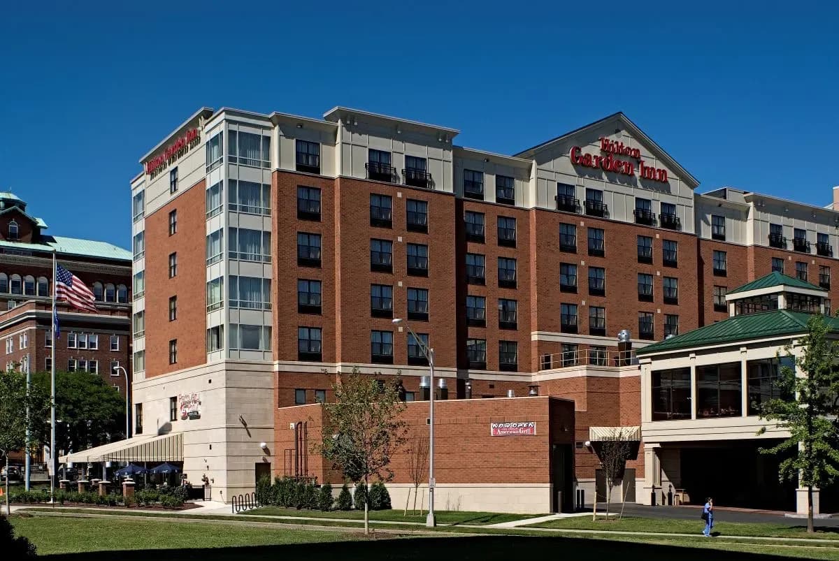 Exterior view of a Hilton Garden Inn hotel, a modern corporate event venue with a brick facade.