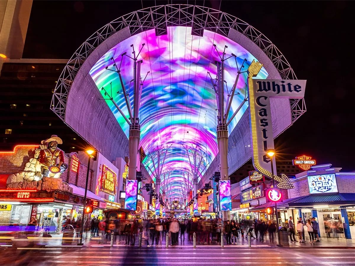 Vibrant Fremont Street Experience in Las Vegas at night, with a colorful LED canopy and bustling crowds.