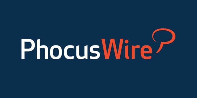 The PhocusWire logo features white and orange text on a dark blue background with a speech bubble icon.