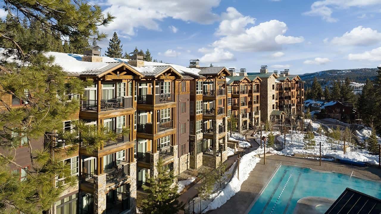 Rustic mountain lodge, a corporate retreat venue, with balconies, a heated outdoor pool, and snow.