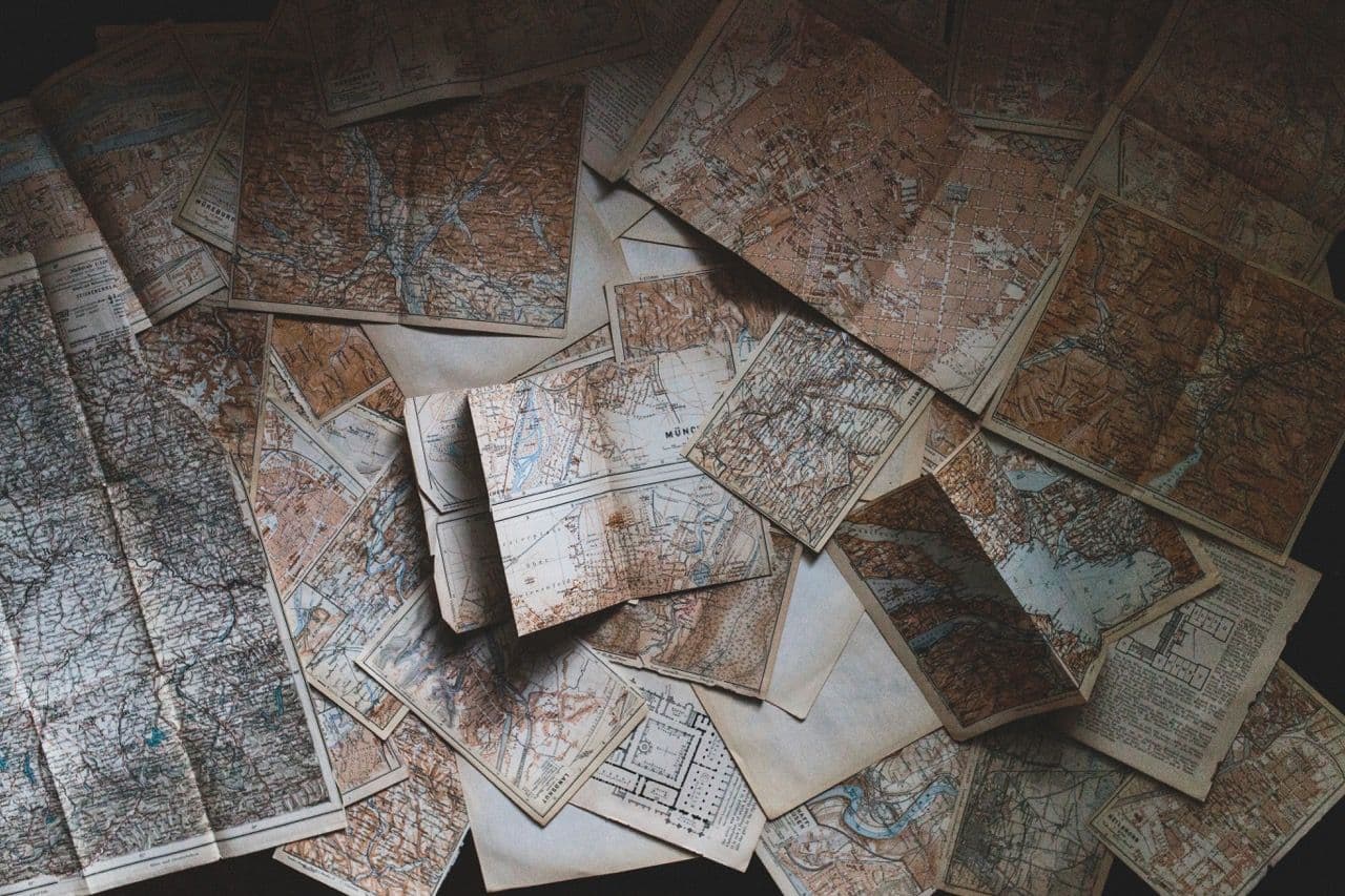 A collection of scattered vintage maps, including one of Munich, ideal for team building activities.