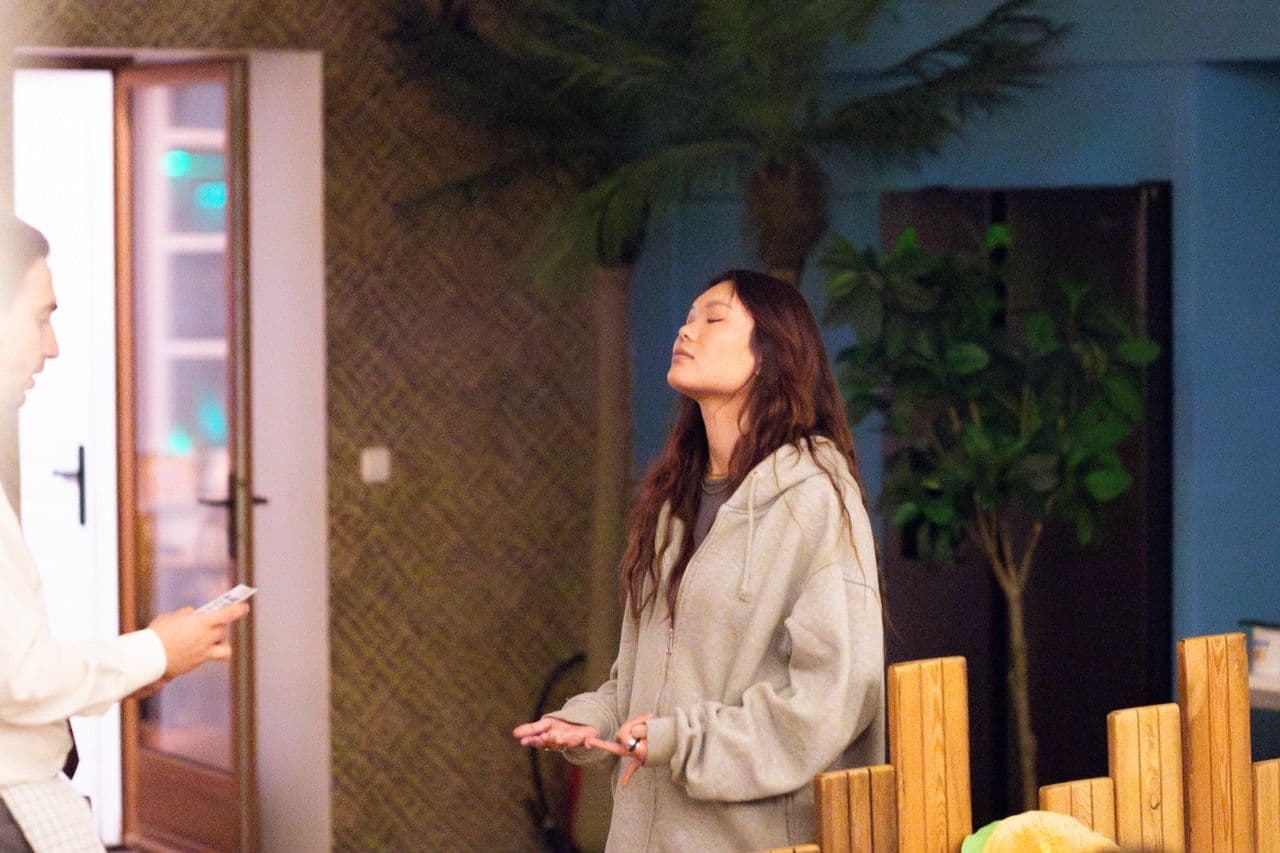 Woman with eyes closed and hands open, engaged in a stress management workshop at an event venue.
